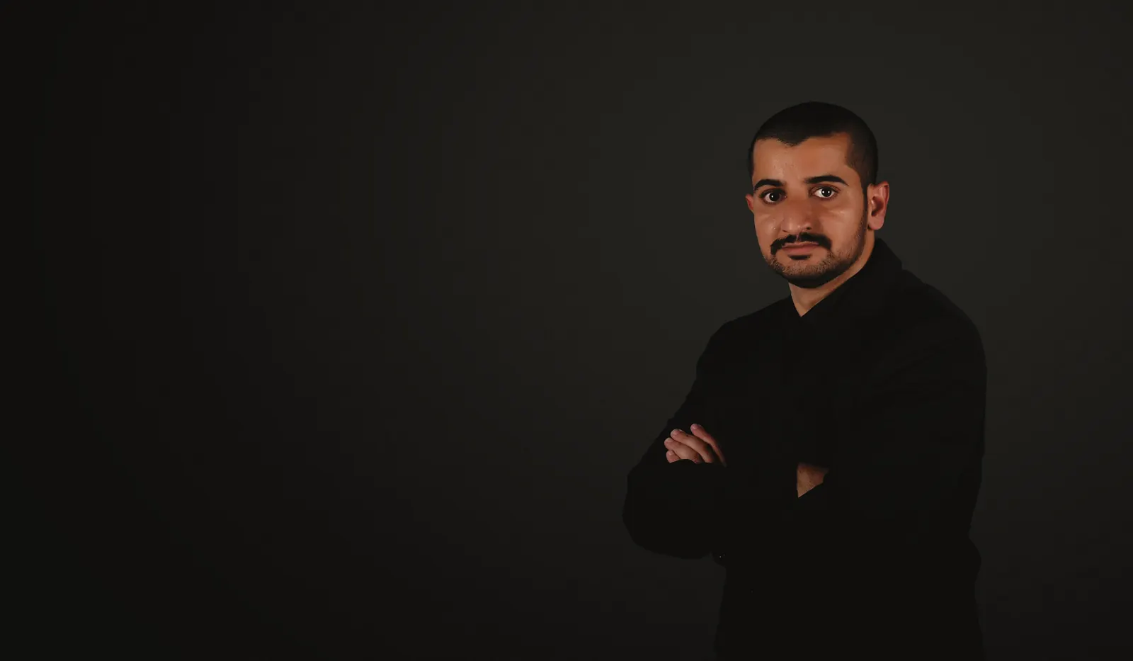 Ahmed Yahya Al Kindi in a black suit, photographed in a studio